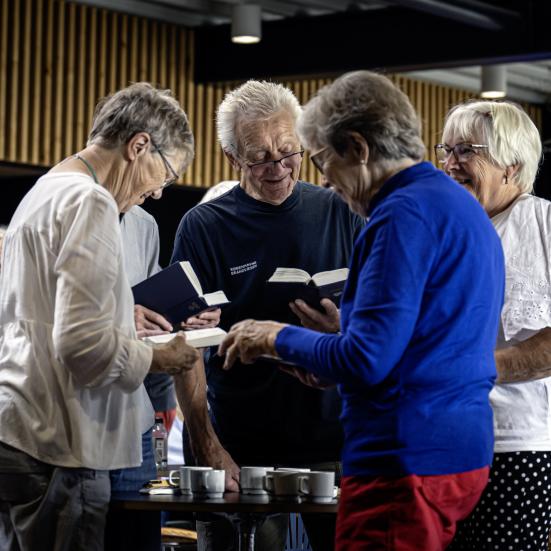 Fire deltagere synger fra Højskolesangbogen.