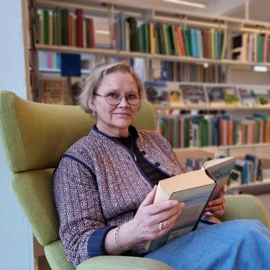 Bibliotekschef Karin Marcussen med en bog på Gribskov Biblioteker.