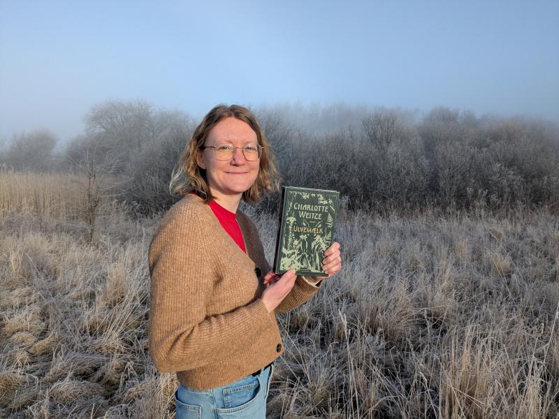 Lea fra biblioteket med Ulvemælk i hånden.
