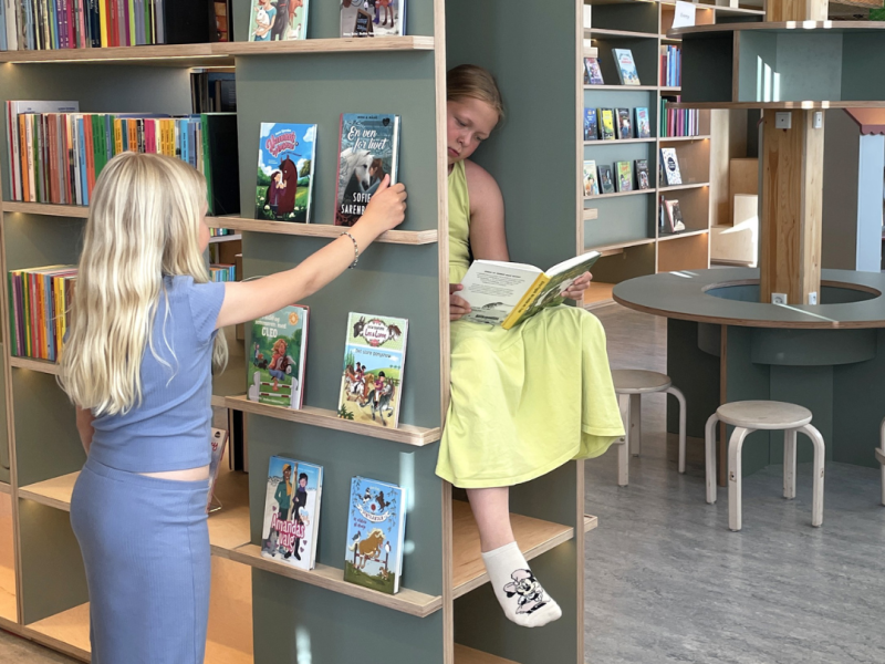 To piger der vælger bøger på Helsinge Bibliotek