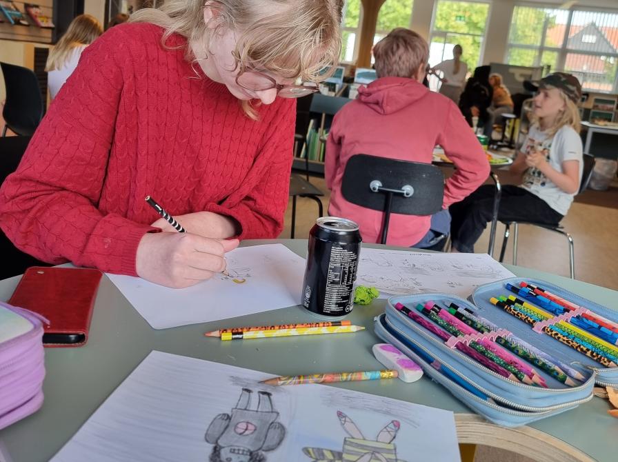 Piger tegner på et papir.