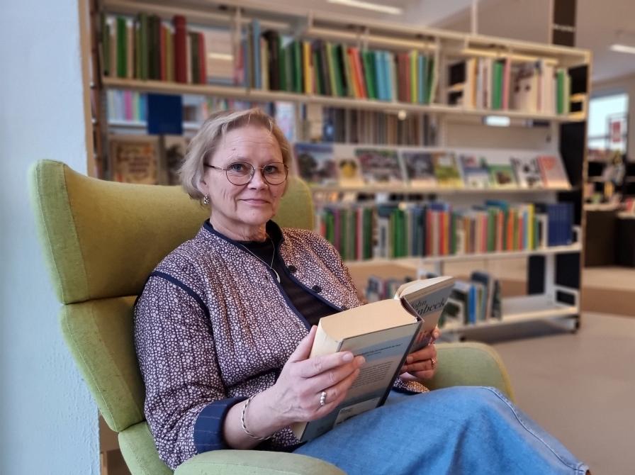 Bibliotekschef Karin Marcussen med en bog på Gribskov Biblioteker.